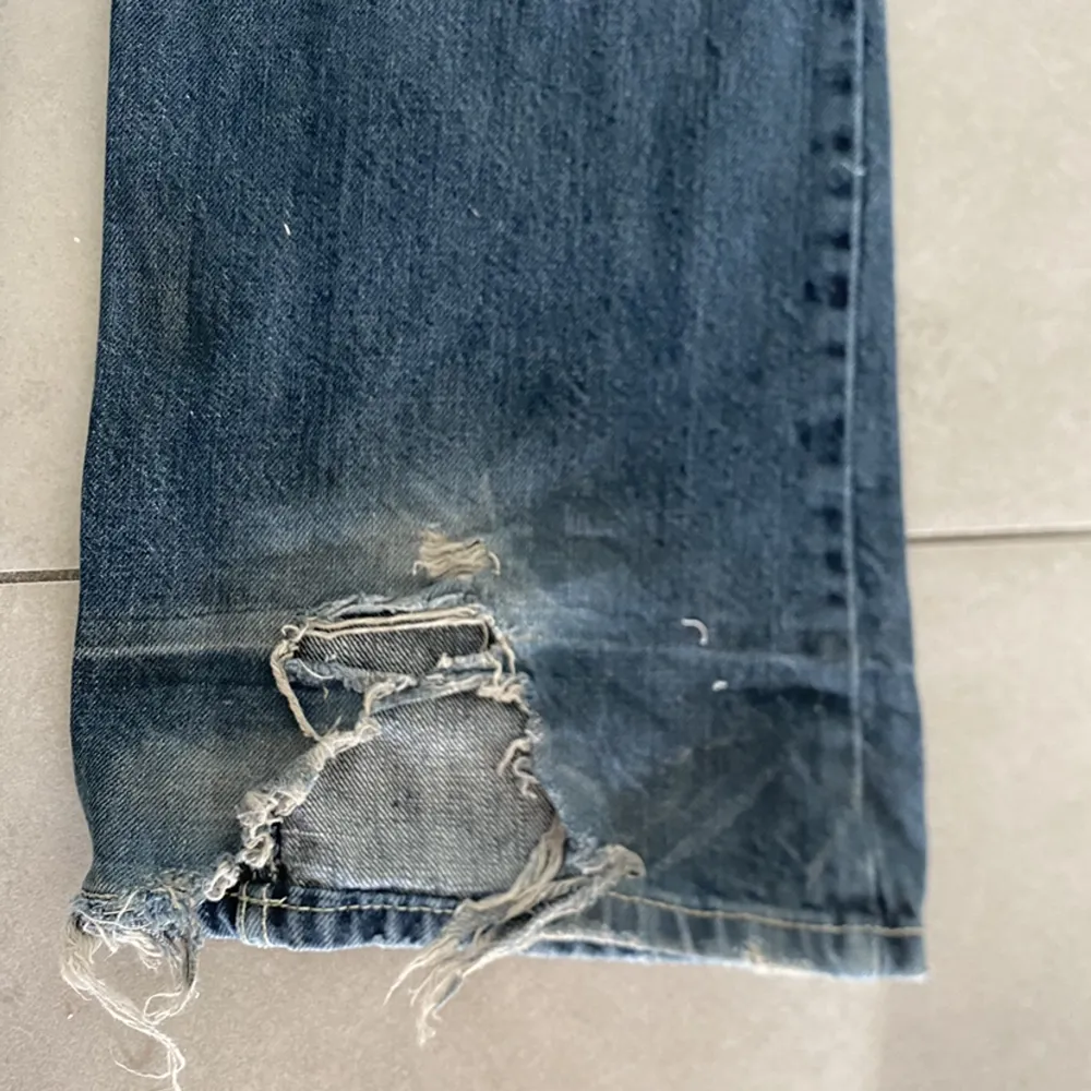 Lågmidjade blåa jeans. Har en del slitningar (se sista bilden) så därför säljer jag billigt. Midjemåttet är 75 och innebenslängden 81. Jeans & Byxor.