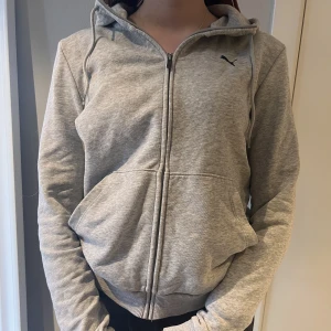 Puma hoodie - Grå hoodie Puma. Använd fåtal gånger men i väldigt bra skick. Förstår inte riktigt storleken men jag skulle säga att den sitter som en S.