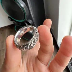 Stainless steel vattentålig silver ring med kedja på som snurrar/rör på sig.  Säljs för den är för stor för mig och använder ej.  Strl S för män så kanske sitter lite större på tjejer. Skriv vid fler frågor :)