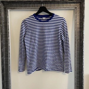 Blå och vitrandiga tröja från Arket - Snygg långärmad tröja i blått och vitt från Arket i storlek S.