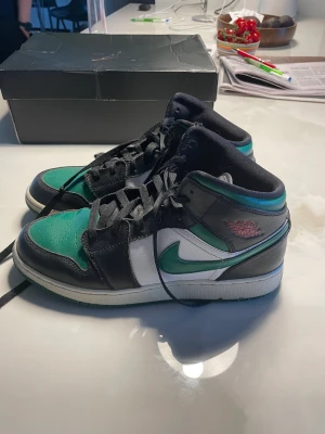 Air Jordan 1 Mid (GS) - Färg Black/Pine Green White Gym Red. Storlek 40 (7). Bra skick. Ca 8/10. Med kartong