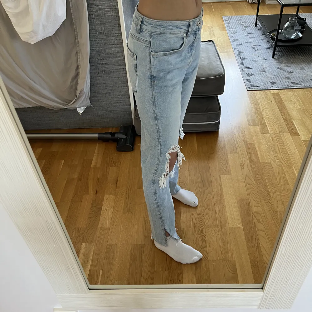 Ett par blå jeans från Zara med ripped hål på båda knäna samt en kort slits nedtill. Använda endast ett par gånger och kommer inte längre till någon användning. Byxorna är i storlek M. Finns inte att köpa på butik idag. De går att styla riktigt fint . Jeans & Byxor.