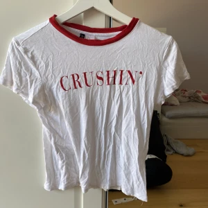 Vit T-shirt med text - Crushin’ T-shirt köpt på h&m lite genomskinlig men fint med non röd bh under 