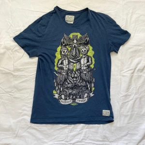 T-shirt med tryck - Mörkblå tisha med tecknat tryck. Angiven stl är M men passar även XS och S. Använd helst ”köp nu”, hör av dig för bilder o frågor!🌀