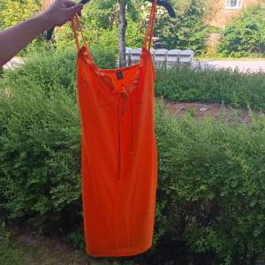 Säljer En Orange klänning i St. 36 andvänd en gång.
