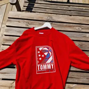 En snygg röd Tommy Tröja.  Finns en liten fläck på märket, därmed det billiga priset.  Skick 7/10