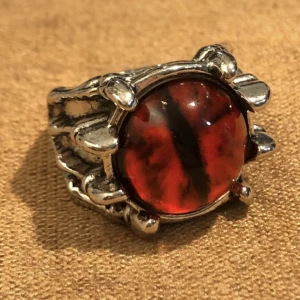 ring med rött öga - cool ring med en hand som håller i ett rött öga! okänd metall.