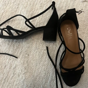 Svarta klackar - Snygga svarta klackar med knytdetalj som tyvärr inte används.  Köpt via Plick så vet inte vart de kommer ifrån. Aldrig använda utan mig och ser inga tecken på användning. 