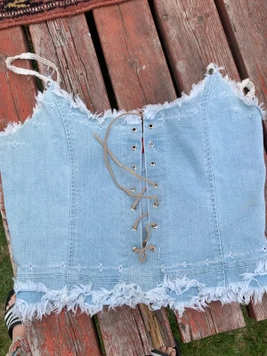 Denim linne  - Linne av jeans material med äkta läder snörning över bröstet 