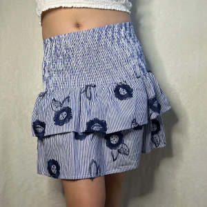 Stockholmskjol - En otroligt fin och populär kjol, kan användas som tröja med, går även att vika ner, aldrig sett en finare kjol än denna, wow! En blå vit kjol med blommor på, stretchigt material. Går att pruta ner.