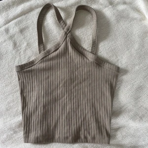Topp - Beige topp från ginatricot i ribbat material. Säljer pågrund av att den ej används