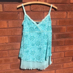 Blått linne, y2k - Ett blått/turkost linne med blommigt mönster och paljetter på, köpt på Lindex på cirka 90/2000-talet. Ungefär 72 cm långt. Finns lite lösa trådar och en paljett har ett hål i kanten. Har tvättat bort fläckarna!! Jag kan ta fler bilder om man vill🩷