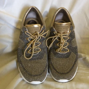 Michael Kors skor - Äkta mk skor. Guldblingiga gympaskor stl 39. Obetydligt använda. Gått utomhus 2 ggr. 