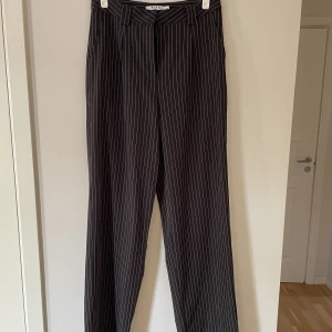 Kritstrecksrandiga kostymbyxor - Långa kostymbyxor i rak modell,  bra skick, två fickor i fram, säljer pga använder ej