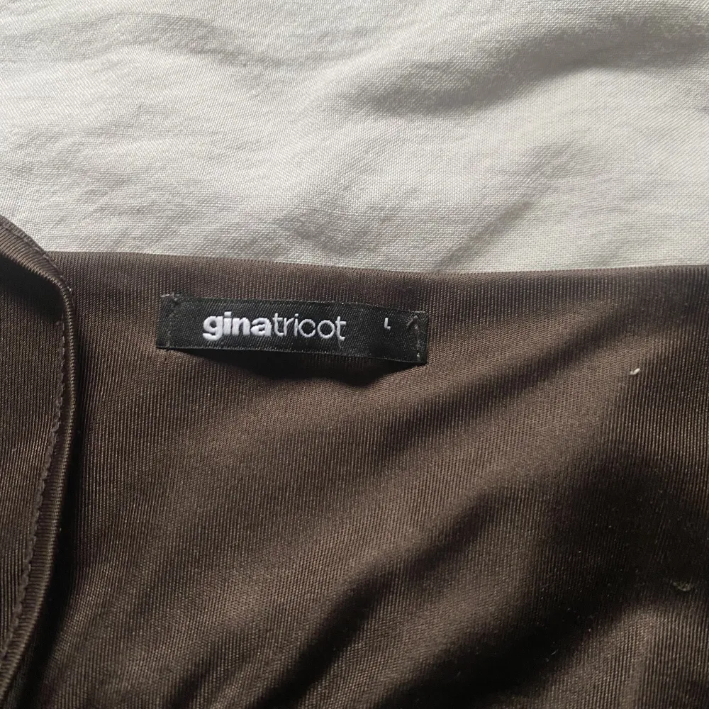 Jättegulligt brunt linne från Ginatricot! Rosetten som man knyte rmed banden på tröjan är lite slitna som man ser på bild 2 men annars är den i gott skick! 😍den har även justerbara band! . Toppar.