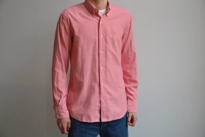 Ralph Lauren skjorta - Rosa Ralph Lauren skjorta i skönt bomullsmaterial. Skjortan är i väldigt fint skick och i storlek Medium! Skriv vid eventuella frågor. **EGNA BILDER EJ FRÅN HEMSIDA!**