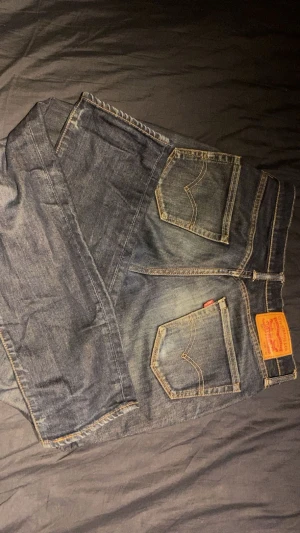 Levis jeans  - Snygga Levis jeans, lite slitna längst ner i byxbenet, tappat lite färg på rumpan. Annars super sköna. Har växt ur dem.