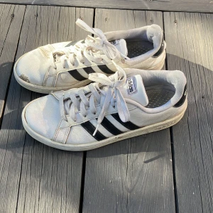 Adidas skor - Adidasskor av läder/skinn, relativt slitna men fullt fungerande. Hål i ena hälen men det går inte igenom till sulan. Jag tror att modellen heter grand court och storleken är 41 1/3. 