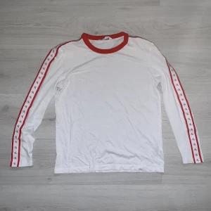 CK tröja - Tunn tröja från Calvin Klein. Vit med röda detaljer längs med armarna. Den är i nyskick. Nypris 359kr. Storlek S.