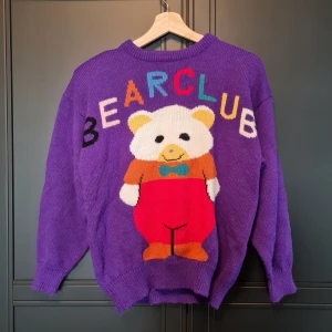 Vintage, stickad tröja med motiv  - Vintage tröja i toppkvalite med motiv av en björn, med texten "BEARCLUB".   Svårt att säga hur gammal tröjan är exakt då jag inte kan hitta något om märket, men den är åtminstone äldre än mig (19 år) 