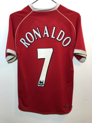 Manchester United fotbollströja 2006/2007 Ronaldo - Manchester United fotbollströja 2006/07 med Ronaldo på ryggen i tjockt material. Tröjan är autentisk. Skicka ett meddelande för fler bilder, frågor eller annat! Bud är välkomna!