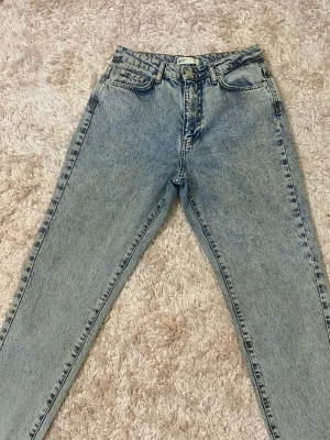 Gina tricot jeans  - Jätte fina mom jeans! inte använt så mycket råka lägga läppstift på jeansen annars Syns det inte så mycket. Köpt för 250