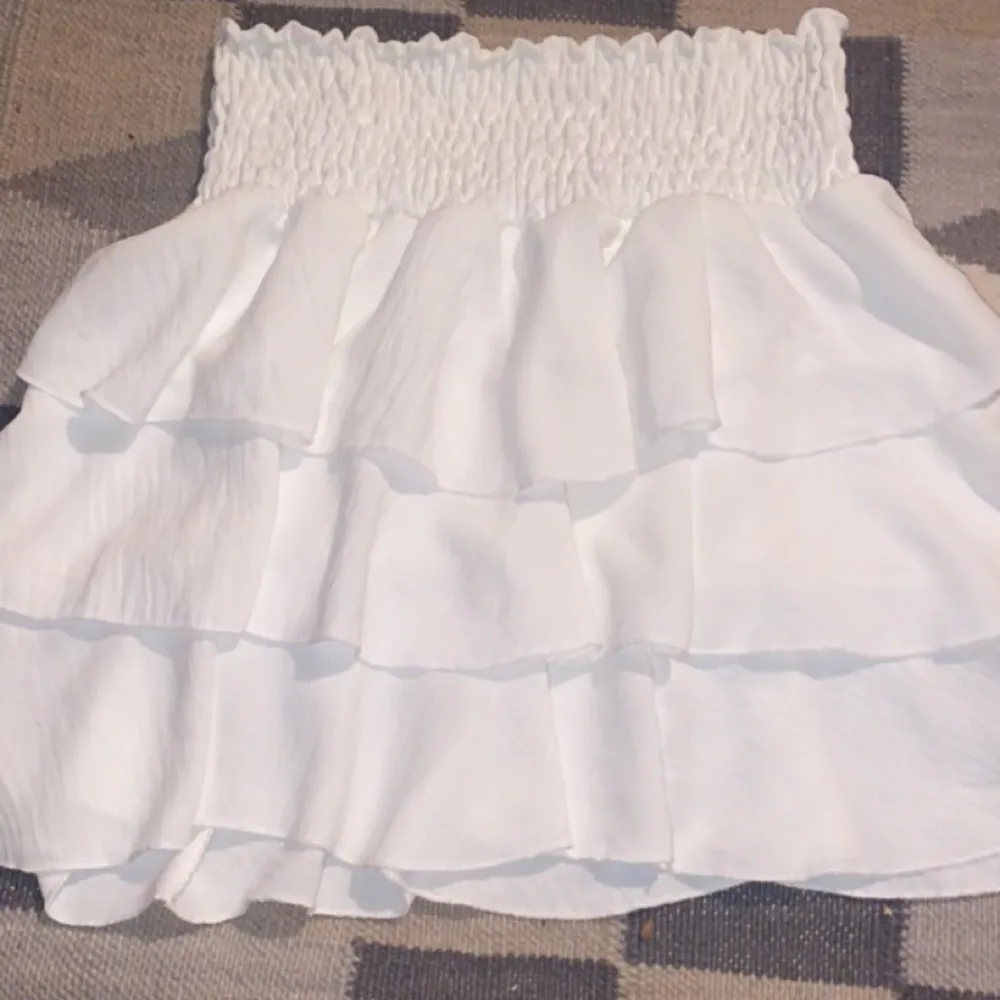 Vit volang kjol ifrån Grekland som är aldrig används. Materialet är väldigt stretchigt vid magen så den är one size <3. Kjolar.