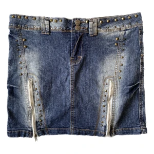 Jeanskjol med nitar - Såå fin jeanskjol med nitar! Strlk 40. Mått; 43cm i midjan (mätt rakt över) & 38 cm i kjollängd ( mätt p sidan) Inte sätt några defekter.