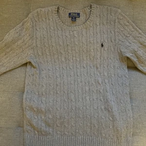 Ralph Lauren Grå Kabelstickad Tröja - säljer min kabelstickad ralph lauren tröja. det är storlek XL, men den passar som en storlek L