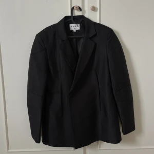 Blazer/Kavaj - Svart blazer/kavaj med knappar i midjan.  Nypris 769kr  Använd vid ett tillfälle. Som ny.
