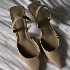 Klackskor - Klackskor från HM med spetsig tå och är i en fin beige färg. Köackhöjden är 8 cm. Använd endast ett fåtal gånger och är i fint skick!
