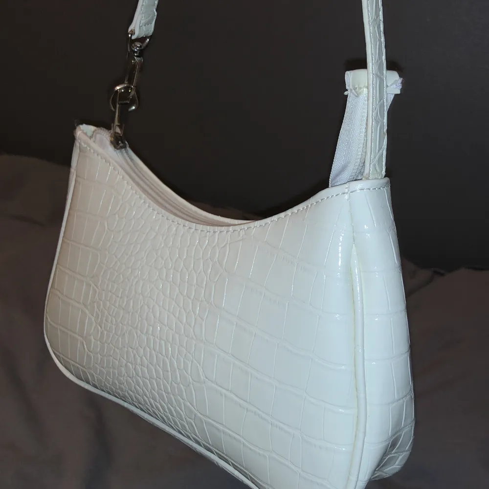 En blank vit väska som är helt fläckfri förutom ett litet tråd trassel vid början Av dragkedjan, men har gott om plats och är ändå väldigt fin! Värdet är 250 kr. Väskor.