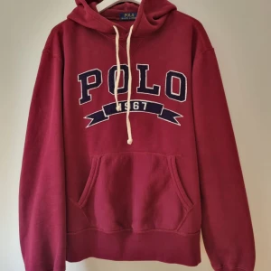 Ralph Lauren Polo Hoodie - Ralph Lauren Hoodie i burgundy/röd. Hoodien år från en äldre kollektion och passar snyggt till det mesta. Hade behållt den själv om den inte var för kort i armarna. 