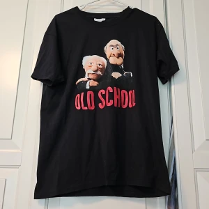 T-shirt med två snubbar från Mupparna.  - Svart T-shirt med tryck på två snubbar från Mupparna. Tvättad och använd en gång. 