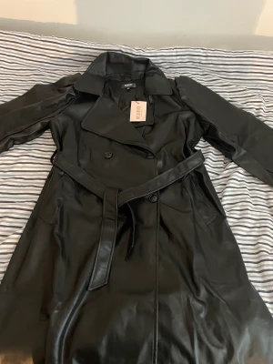 Skinnkappa  - Säljer denna fina skinnjacka/kappa. Den går ända ner till knäna och är helt oanvänd med även prislapp på. Den är i storlek 36. 