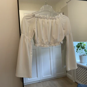 Vit topp från Zara - En axellös, väldigt söt topp från Gina Tricot med ”trumpetärmar”. I fint skick utan anmärkningar 🤍 Storlek XS 