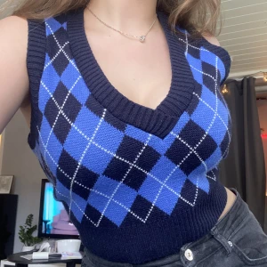 STRADIVARIUS V-neck stickad tröja (S) - Stradivarius blå/marinblå tunn stickad tröja/väst (rutmönster). Nästan helt oanvänd och i galant skick. Ett mycket snyggt och färggrant plagg som passar med flera lager kläder och som den är.
