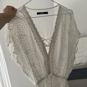 Strandtunika - Söt strandtunika i vitt med spetsdetaljer. Transparent i tyget. Kort modell som kan användas som topp eller kort klänning beroende på hur lång du är. Köpt på bikbok men kommer inte till användning så nu hoppas jag någon annan får nytta av den ☀️🫶🏼