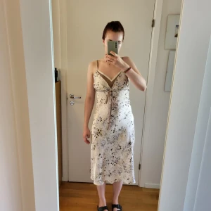 Vacker silkesklänning - Somrig silkesklänning med broderidetaljer och snörning framtill. Säljer då den inte kommit till användning.