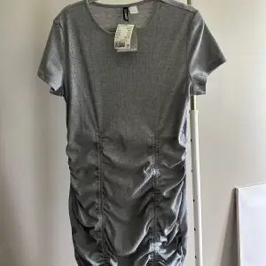 Super fin t-shirt klänning från H&M i storlek L, rynkad på sidorna och fram, går att välja hur mycket man vill ha. Helt ny med lapparna kvar! 