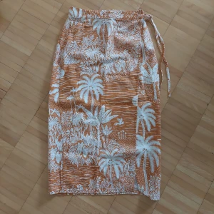 Mönstrad orange kjol - Mönstrad orange kjol från H&M, oanvänd.