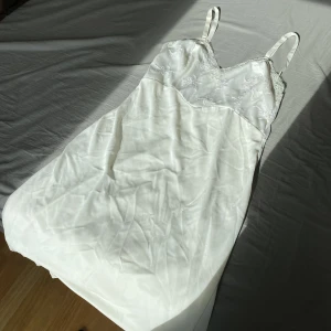 Vintage slipdress - Superfin vintage klänning med spets-detaljer! Längden är till lite över knäna på mig som är ca 167. Strapsen går att reglera. Storleken skulle jag säga är en S, men den passar nog både XS och M. Finns några väldigt svaga fläckar på klänningen (se bild 3)