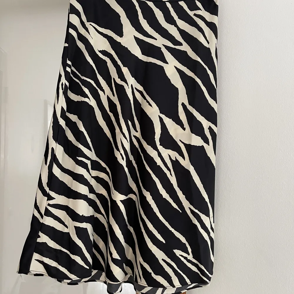 Super fin kjol med zebra ish mönster. Välanvänd med vissa skavanker, dragningar i tyget och någon fläck som syns på bild. Materialets mönster gör att dessa inte syns när man använder kjolen. Låt inte detta avskräcka dig då den är super fin !. Kjolar.