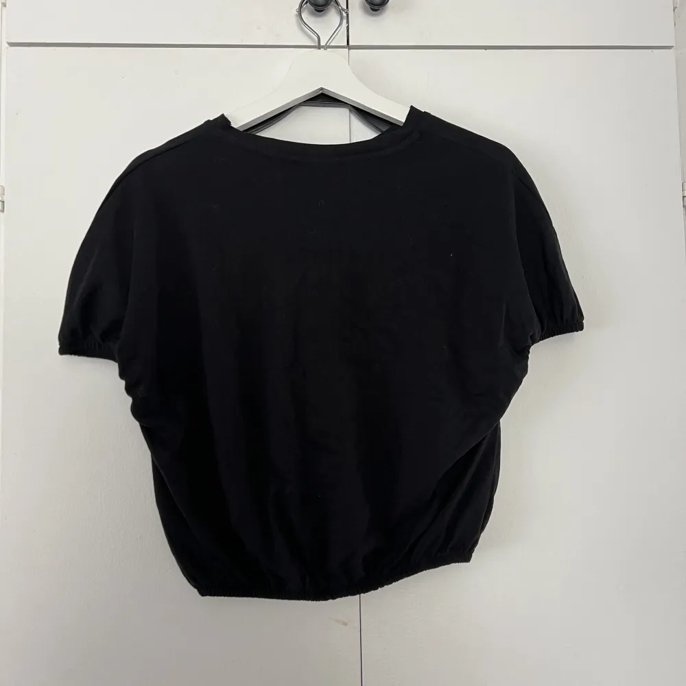 En svart tröja med lite figurform i midjan och croppad. I storlek S . Säljer för 50kr . T-shirts.