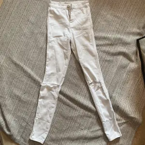 Vita jeans med hål vid knäna i storlek XS