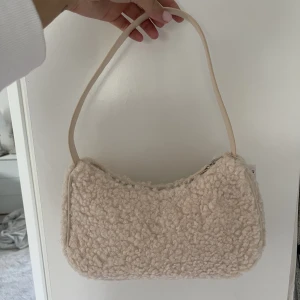 Gräddvit pälsväska - En helt oanvänd gräddvit pälsväska från hm. Lappen sitter kvar.