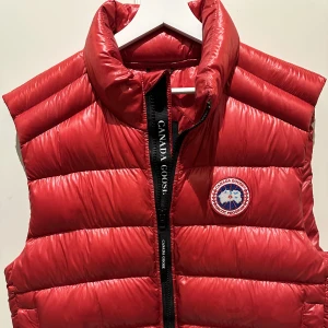 Canada Goose crofton vest Röd - Vinröd väst i lättviktsdun från Canada Goose i polyamid. Använd 2gånger då den var fel storlek för mig. Nypris på hemsidan är 5899kr