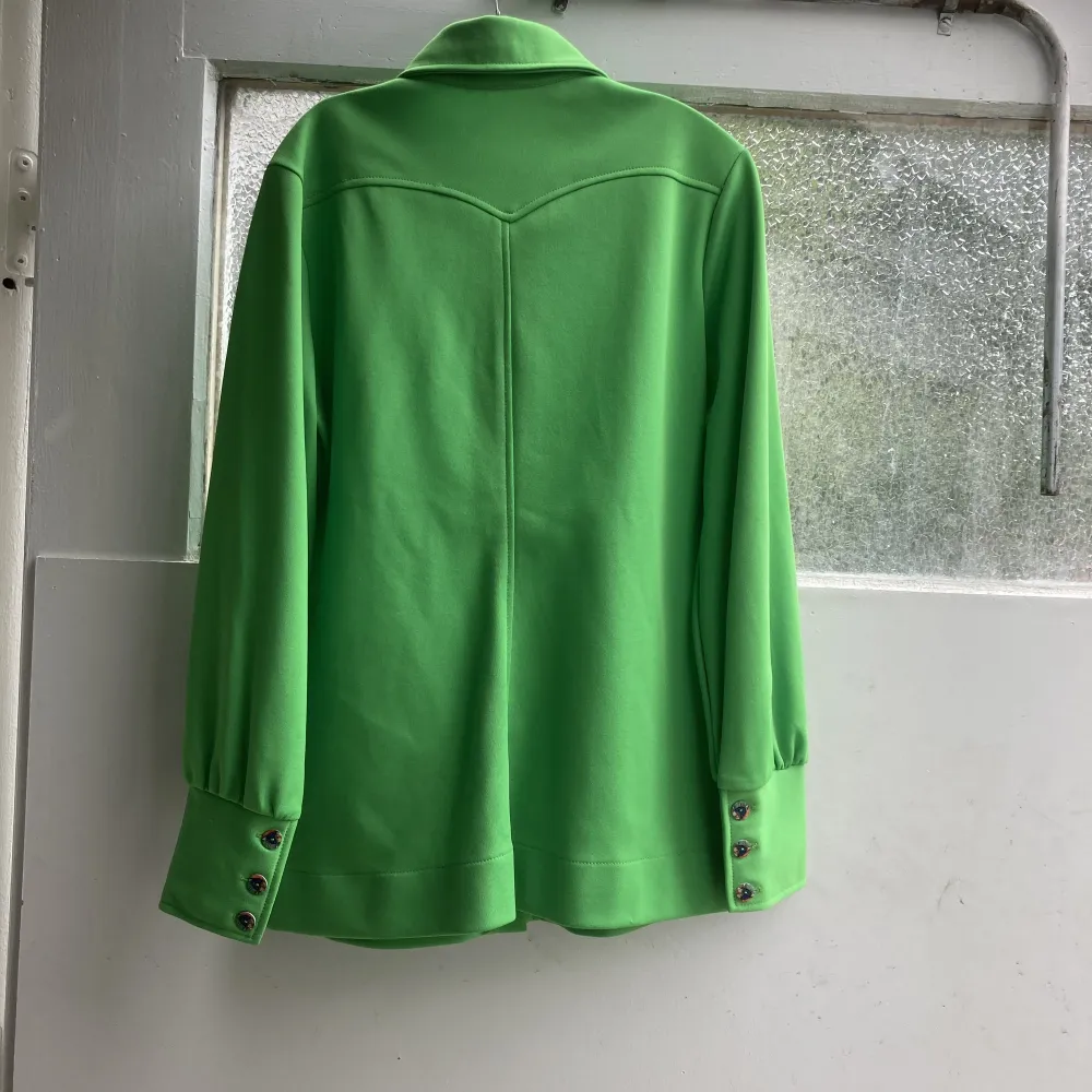 Unik grön Vintage skjorta/blus från 60-70-tal. Otroligt fräsch och ett mycket mjuk material men inga lappar kvar kring detta. Vackra pärlemoknappar även på macheterna. Snyggt sytt ok i ryggen. . Blusar.