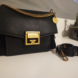 Givenchy gv3 small - Liten väska med struktur i mocka och läder med detaljerad kedjehandtag, avtagbar axelrem, vintage metallfäste framtill, dragspelssidor, innerfack och ficka med dragkedja. Används några gånger. 