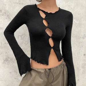 Långärmad svart tröja  - En långärmad svart tröja som har fyra hål i. Den är helt ny  och har prislapp på. Den är i ett väldigt bra skick. 